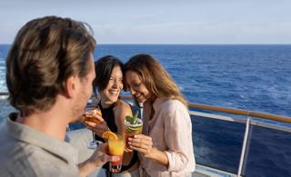 Friends enjoy refreshing cocktails on the deck of MSC World Europa, with the sea and sky as a stunning backdrop | MSC Cruises