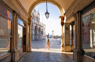 A woman stands in an archway leading to St Mark's Square in Venice, inviting exploration of this beautiful destination | MSC Cruises