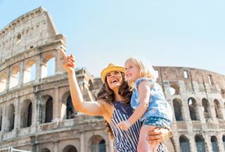 Une mère joyeuse porte sa fille près du Colisée à Rome, célébrant ensemble leur aventure méditerranéenne | MSC Croisières