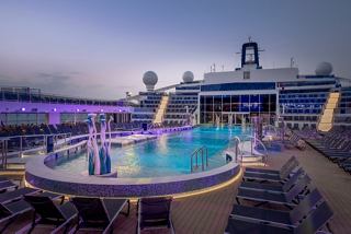 L'area invitante della piscina La Plage sulla MSC World America, con terrazze e lettini al crepuscolo | MSC Crociere