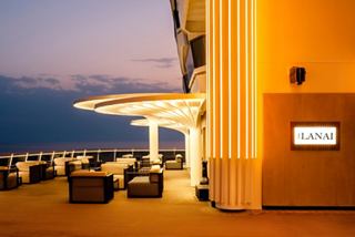 A serene sitting area on the MSC World America, overlooking the sea with palm tree lights and a beautiful sky | MSC Cruises