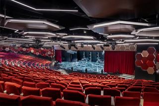 Una vista spaziosa del Teatro Mondiale, con posti a sedere vivaci e un palcoscenico pronto per l'intrattenimento | MSC Crociere