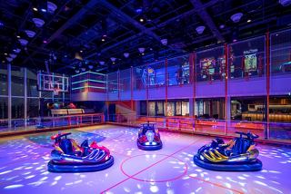 A vibrant entertainment area with bumper cars under colourful lighting in MSC World America | MSC Cruises