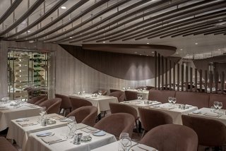 A stylish dining area in Les Dunes Restaurant featuring elegant tables and chairs for a memorable dining experience | MSC Cruises