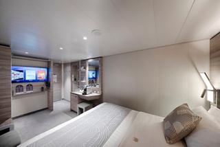 Ein luxuriöses Innen-Suite des MSC Yacht Club mit einem Doppelbett und modernen Annehmlichkeiten | MSC Cruises