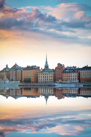 Reflecting buildings and clouds at sunset over calm waters in Stockholm, highlighting the beauty of Northern Europe | MSC Cruises