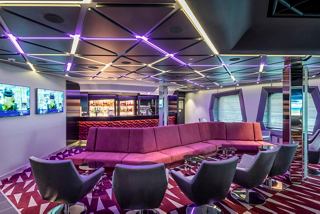 A modern bar area with comfortable seating and vibrant lighting, perfect for socialising and enjoying drinks | MSC Cruises