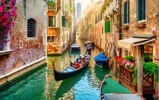 A serene Venetian canal lined with charming buildings, featuring gondolas and vibrant flowers | MSC Cruises