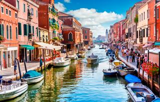 A picturesque canal in Venice lined with colourful buildings and boats, inviting exploration and adventure | MSC Cruises