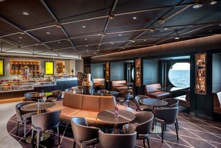 A warm and inviting lounge area with comfortable seating and a central table, perfect for relaxation and socialising | MSC Cruises