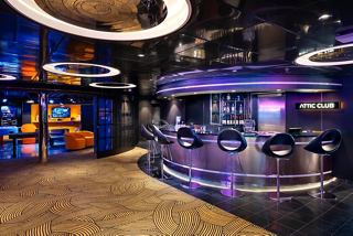A vibrant lounge area featuring a stylish bar counter and comfortable seating for guests to enjoy socialising | MSC Cruises