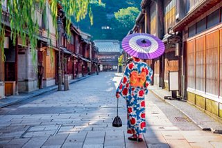 A woman in a kimono walks down a Japanese street, holding an umbrella and enjoying the peaceful atmosphere | MSC Cruises