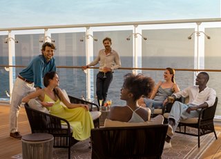 Des amis profitent de boissons et de conversations au coucher du soleil sur le pont du MSC World Europa | MSC Cruises