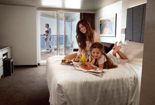 A family enjoys a relaxing morning together in their cabin on MSC World Europa, sharing breakfast and laughter | MSC Cruises