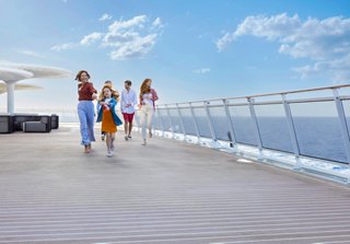 Eine Familie genießt gemeinsam Zeit auf dem Deck der MSC World Europa, umgeben von Himmel und Meer | MSC Cruises