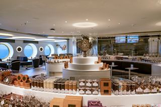 A spacious bar area featuring a beautiful sculpture, offering a delightful selection of sweets and chocolates | MSC Cruises