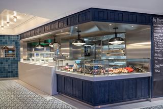 A vibrant seafood counter at La Pescaderia restaurant, offering fresh selections in a welcoming atmosphere | MSC Cruises