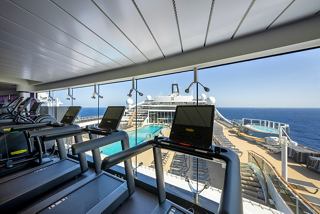 A modern gym area with treadmills overlooking a stunning ocean view, inviting active relaxation | MSC Cruises