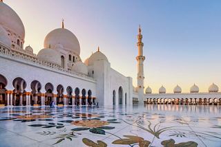 The magnificent Sheikh Zayed Mosque in Abu Dhabi showcasing stunning details against a sunset sky | MSC Cruises