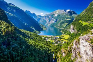 Breathtaking view of Geirangerfjord surrounded by majestic mountains and vibrant greenery | MSC Cruises