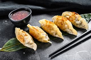 Deliciosos dumplings gyoza fritos servidos con salsa para mojar y palillos | MSC Cruceros