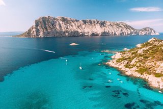 Une vue à couper le souffle sur l'île Tavolara et les eaux cristallines de la piscine naturelle de Molara en Sardaigne | MSC Croisières