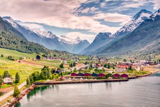 Ein friedliches norwegisches Dorf am See, umgeben von majestätischen Bergen und üppigem Grün | MSC Cruises