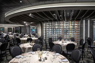 A modern restaurant setting with elegant tables and a glass wall, inviting guests to enjoy fine dining experiences | MSC Cruises