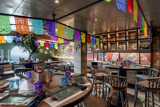 A vibrant restaurant interior featuring colourful decorations, tables, and a welcoming atmosphere | MSC Cruises