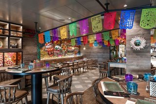 Eine lebendige Restaurantszene mit bunten Dekorationen und einladenden Tischen im HOLA! Tacos & Cantina | MSC Cruises