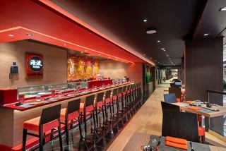 A vibrant corridor leading to the Kaito Sushi Bar with seating and a welcoming counter | MSC Cruises