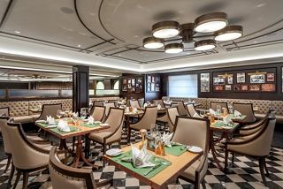 Un cálido comedor con elegantes mesas y sillas, perfecto para disfrutar de una comida agradable a bordo del MSC Euribia | MSC Cruceros