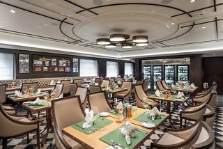 A warm and inviting restaurant setting with elegantly arranged tables and soft lighting | MSC Cruises