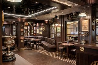 A stylish bar area with wooden furnishings, offering a warm atmosphere for relaxation and socialising | MSC Cruises