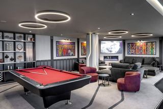 A modern billiard area with a red pool table and relaxing seating, perfect for entertainment on board MSC Euribia | MSC Cruises