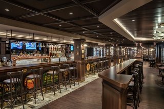 A welcoming bar area with wooden accents and seating, perfect for enjoying drinks with friends | MSC Cruises