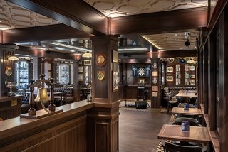 An elegant bar area with warm lighting and wooden furnishings inviting guests to relax and enjoy their experience | MSC Cruises