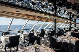 A stylish dining area in the MSC Yacht Club with panoramic sea views and elegant furnishings | MSC Cruises