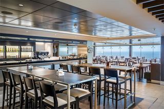 A vibrant bar area with modern seating and a view of the sea, inviting guests to relax and enjoy their time | MSC Cruises