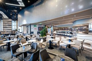 A spacious entertainment area with tables and a bar counter, inviting guests to relax and enjoy | MSC Cruises
