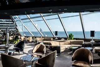 The elegant Top Sail Lounge offers stunning sea views through its glass wall, creating a serene gathering space | MSC Cruises