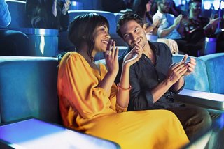 Un couple joyeux partage un rire dans le vibrant Panorama Lounge du MSC World Europa | MSC Croisières