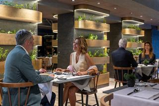Una pareja disfruta de una comida juntos en el restaurante Chef's Garden Kitchen en el MSC World Europa | MSC Cruceros