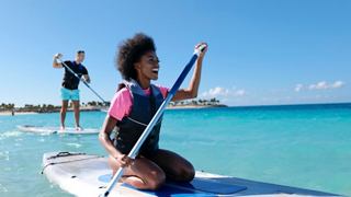 A woman and man paddle boarding together in MSC Ocean Cay | MSC Cruises