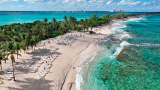Vista aerea di una spiaggia serena sull'isola Blue Lagoon, circondata da acque turchesi e vegetazione lussureggiante | MSC Crociere