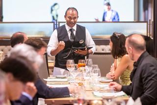 Un camarero sirve bebidas a los invitados en una mesa en Le Grill del MSC Euribia, mejorando la experiencia a bordo | MSC Cruceros