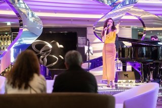 Los huéspedes disfrutan de música en vivo en el Infinity Atrium a bordo del MSC Euribia, rodeados de entretenimiento vibrante | MSC Cruceros