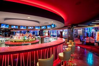 A vibrant casino bar area with illuminated décor and a lively atmosphere awaits guests onboard MSC Euribia | MSC Cruises