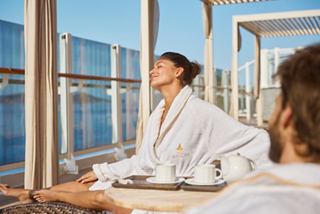 A couple enjoys a serene moment in the solarium of MSC Aurea Spa, with tea and relaxation in focus | MSC Cruises