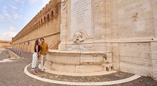 Una pareja disfruta de un momento cerca de una hermosa fuente en Civitavecchia, Italia, mientras explora los alrededores históricos | MSC Cruceros